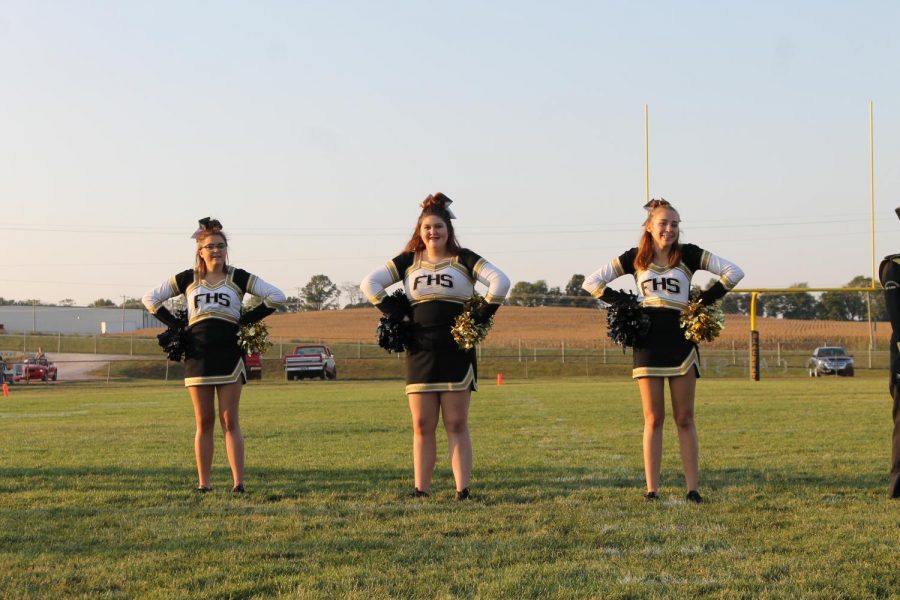 Caylee Wright, Lanie Wade, and Leah Lindsey are lined up on the field waiting for the arrival of the homecoming candidates.