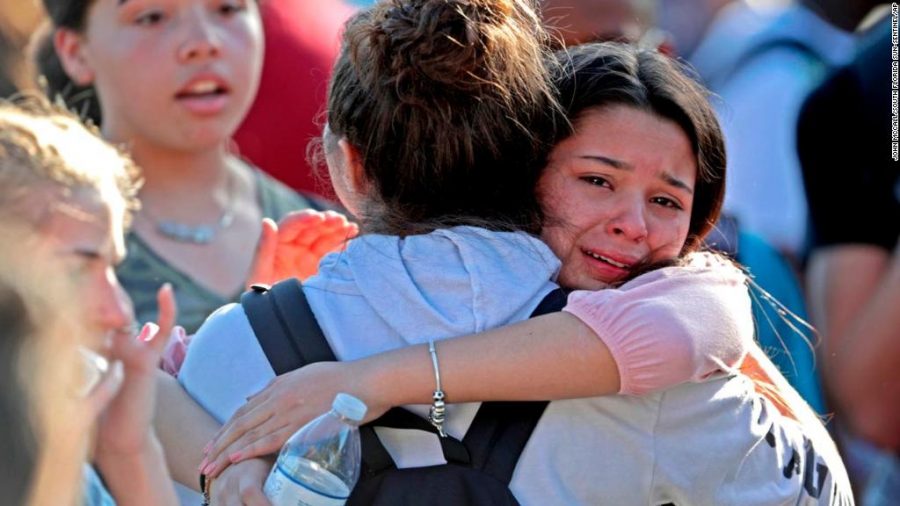 Students released from a lockdown embrace following following a shooting at Marjory Stoneman Douglas High School in Parkland, Fla., Wednesday, Feb. 14, 2018. (John McCall/South Florida Sun-Sentinel via AP)