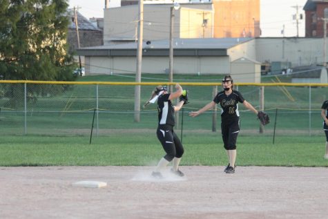 Kylee Bastie catching the ball with the help of Mackenzie Phillips.
