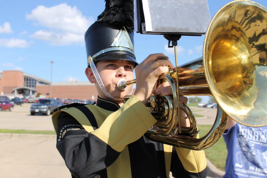 Freshman Jacob Yount warms up for the parade at the Jackson Marching Band Festival