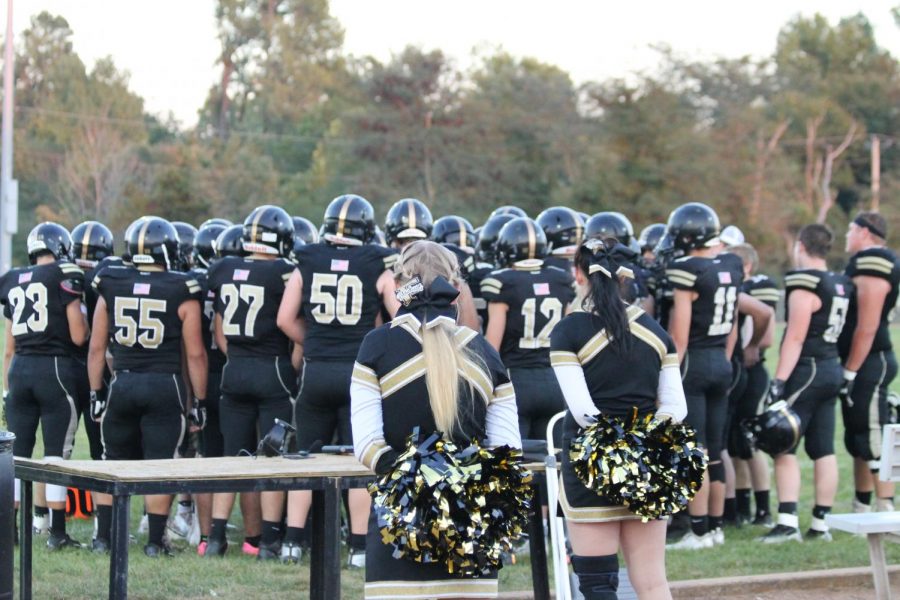 The+Blackcats+Football+team+listening+to+coaches+before+the+game+starts+off.