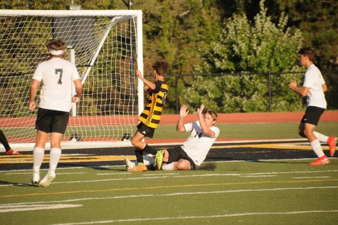 Number 14 Jedediah Dewey mid fall after stopping opponent from scoring a goal.
