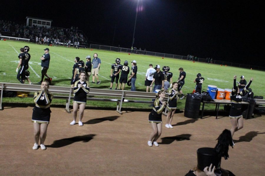 The Cheerleaders getting ready to do a toe touch in mid air. 