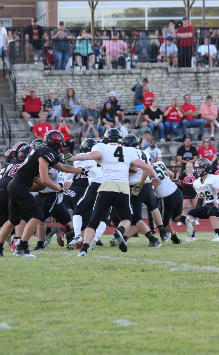 Tim DeSanto blocking a Herculaneum player as the quarterback throws the ball. 