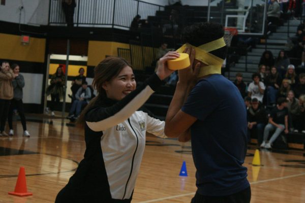 Linda Yang (10) wrapping fellow team member Oscar Millan (10) in yellow streamers.