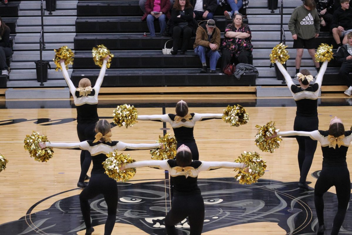 The full team hitting their beat during their pom routine. 