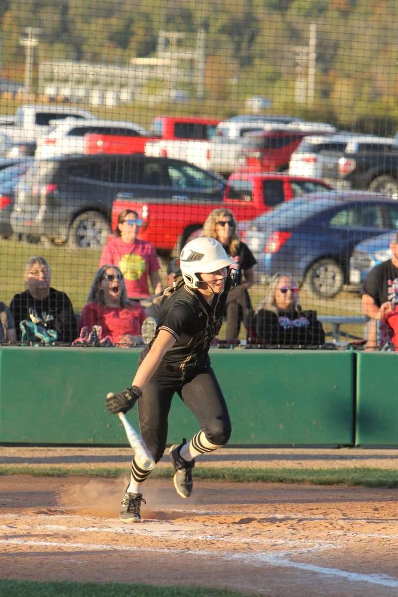 Callie Allgier (12) hits the ball into the outfield, making it to first base. 