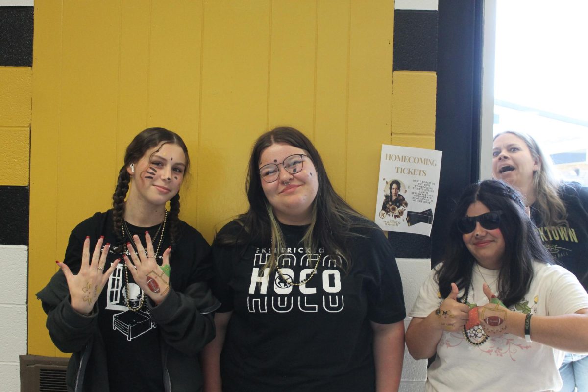 Savanna Pogue (11), Rylee Heady (10), and Valentina Pellegrino (11) posing for a picture while Mrs. Reutzel photobombs through the window. 