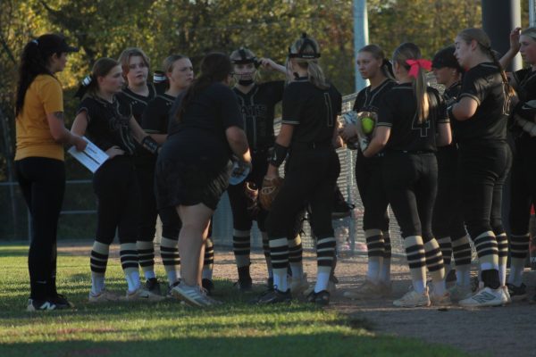 Coach Allgier talks to the players before they take the field to play defense. 